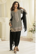 Model wearing the black dhoti salwar kameez with the dupatta draped over one shoulder.