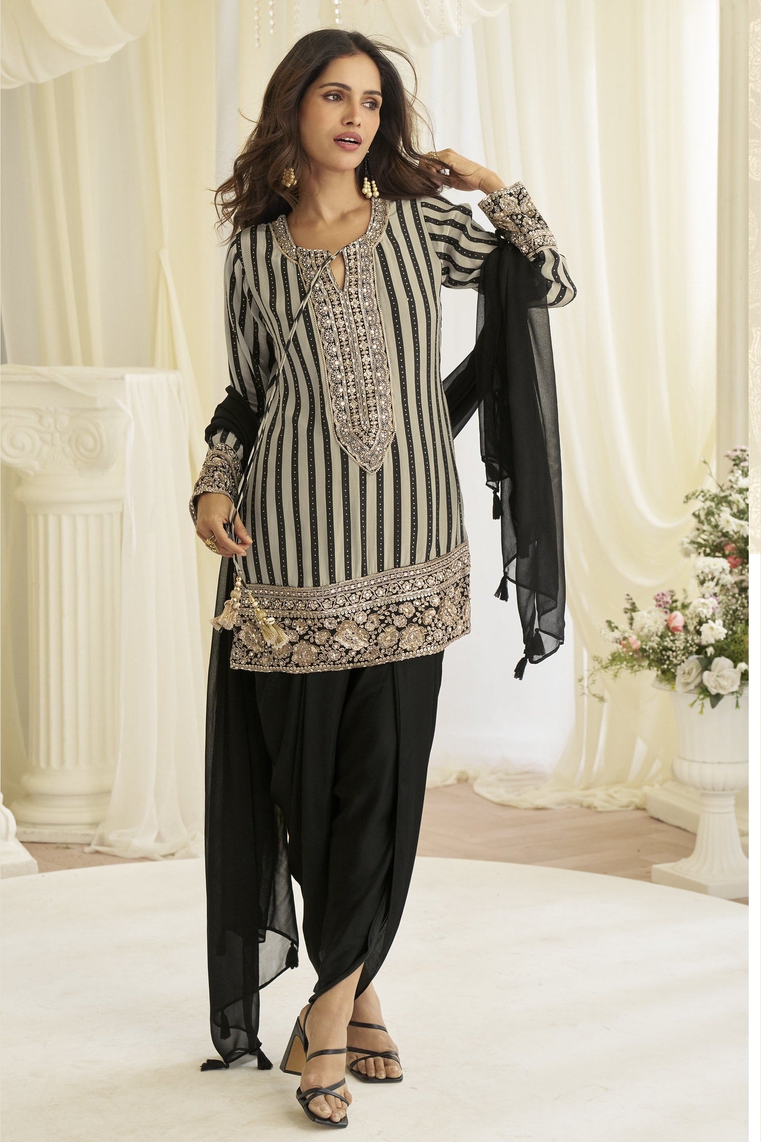 Model wearing the black dhoti salwar kameez with the dupatta draped over one shoulder.