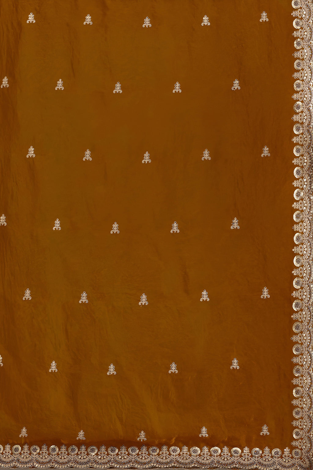 Brown fabric with white embroidered patterns and a decorative border.