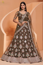 Model wearing an olive green net lehenga choli with multicolour thread embroidery, mirror work and draped dupatta — a rich lehenga for mehndi celebrations with an embellished border.
