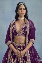 A waist-up front view shows a woman in a purple embroidered lehenga choli for reception with a V-neck embroidered blouse and net dupatta.
