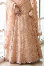 Waist-down close-up of the peach lehenga showing dense floral embroidery, scalloped dupatta border and potli bag — a dreamy engagement lehenga with stone and thread work.