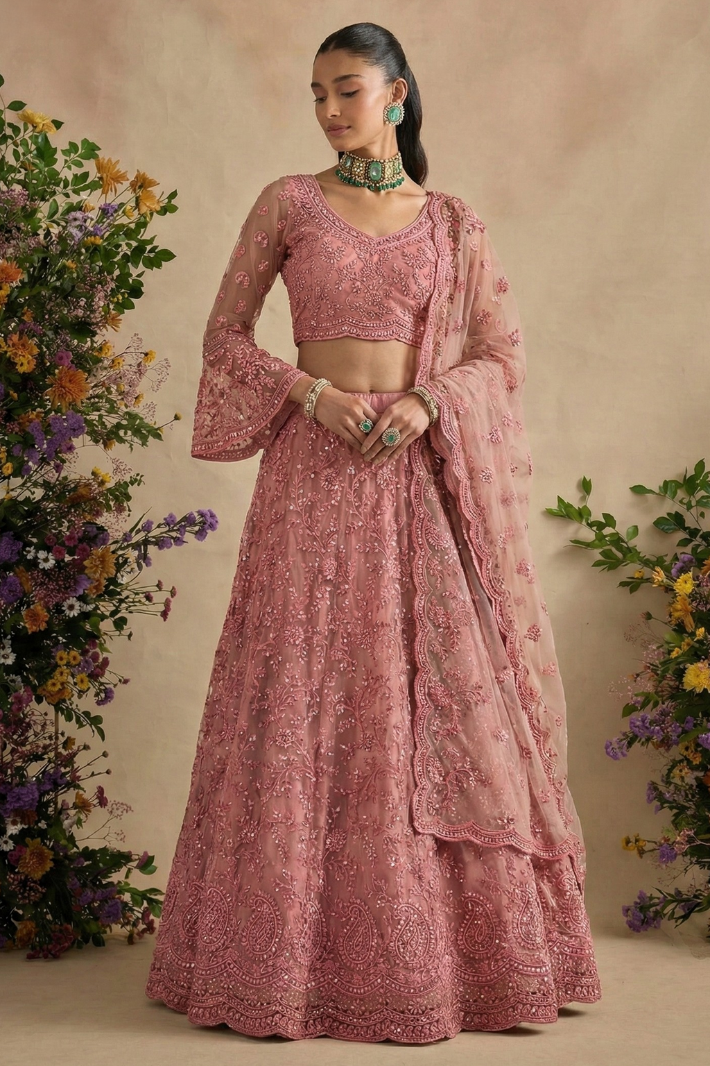 Full front view of the dusty pink lehenga choli with bell sleeves, scalloped dupatta and green jewellery — a lovely engagement lehenga in thread and stone work.