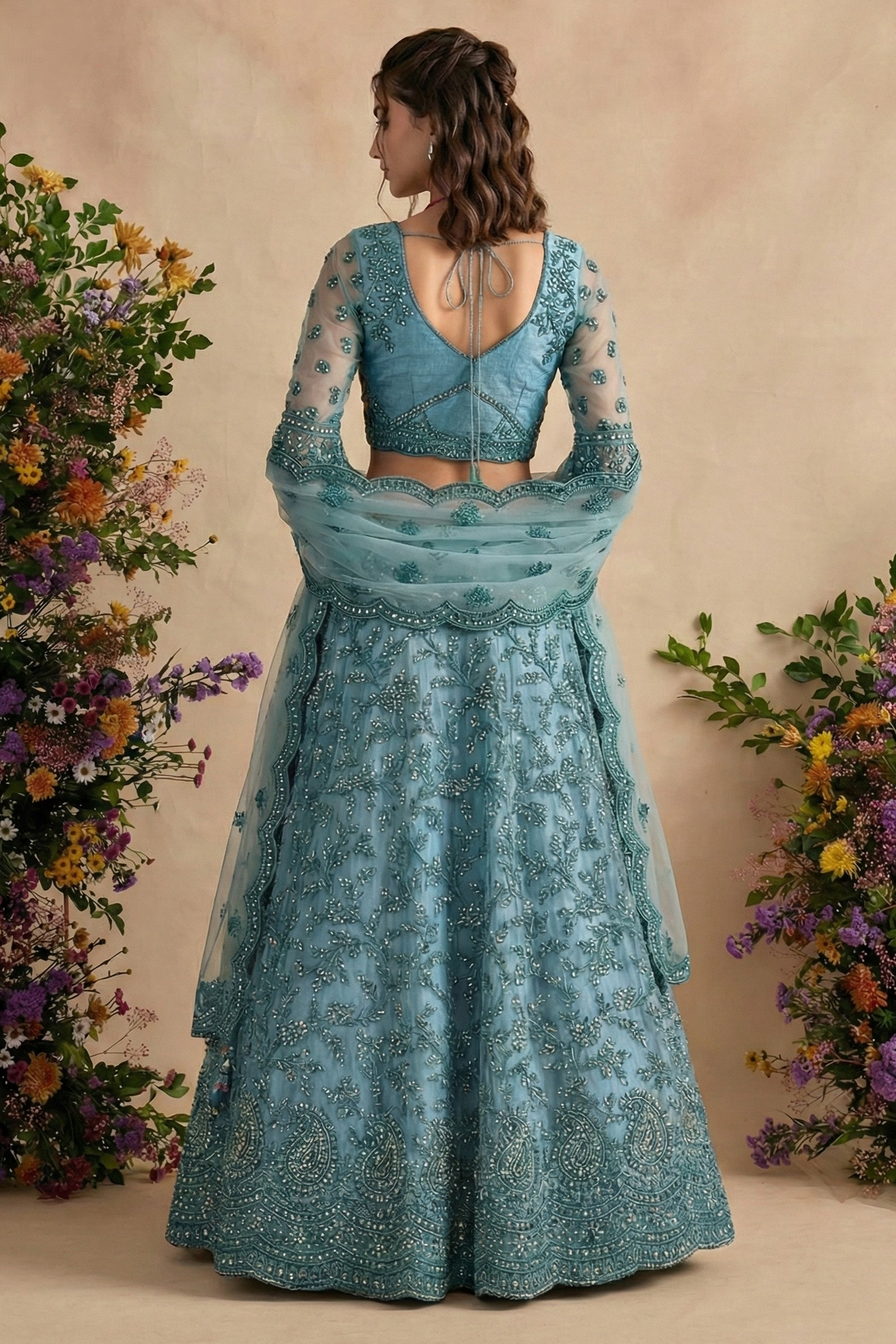 Back view of the teal blouse with open back and dori ties, sheer embroidered sleeves and flared skirt — a detailed indian lehenga choli for wedding celebrations.