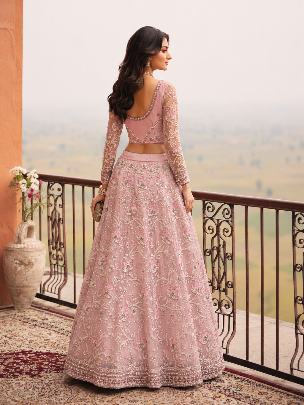 Back side view of Woman wearing a baby pink long sleeve lehenga 