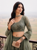 Upper view of a sage green lehenga for wedding guest outfit showing the three quarter sleeve choli with embroidery work detail.