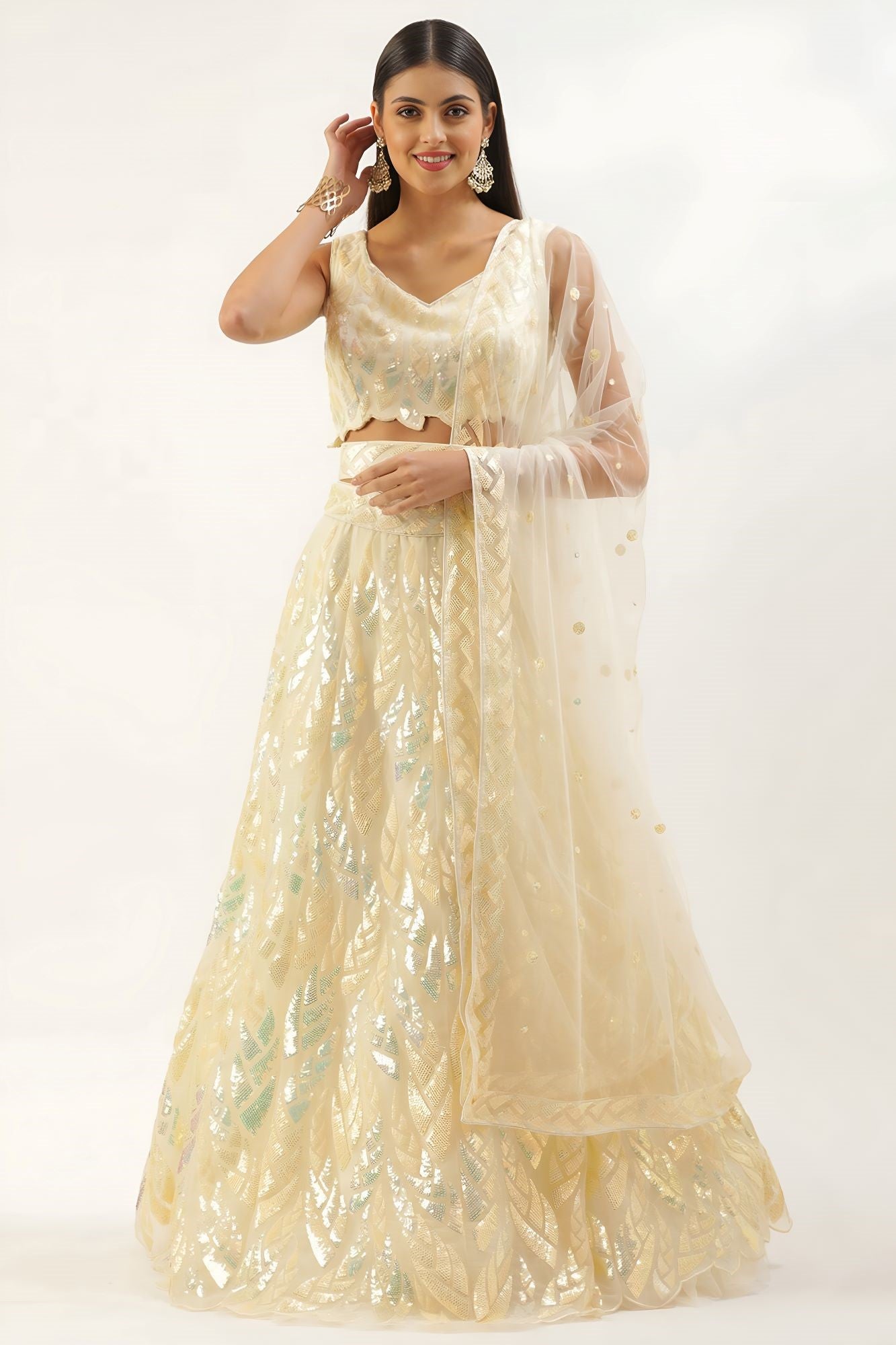 Woman wearing a light-colored traditional outfit with a sheer dupatta on a white background