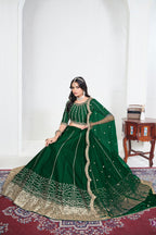Alternate view of a green embroidered lehenga with mirror work on the lehenga skirt, seated pose, full outfit visible. All-over mirror work.