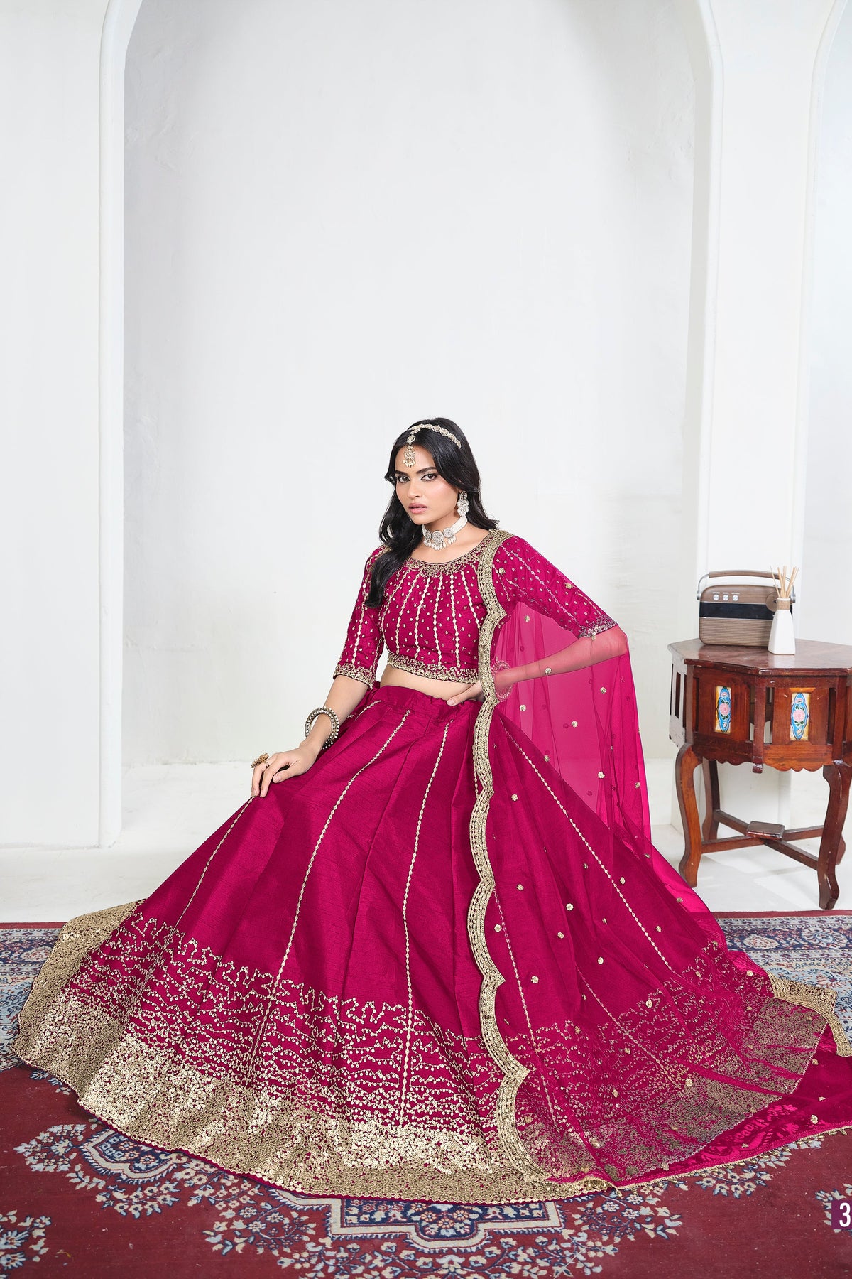 Alternate view of a pink mirror lehenga with mirror work on the lehenga skirt, seated pose, full outfit visible. All-over mirror work.