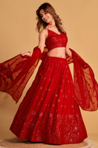 Alternate full-length view of a reddish pink engagement dresses for women lehenga with zari and sequin embroidery on the choli and lehenga.