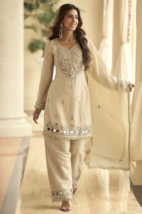Woman wearing beige designer Plazo Suits for Party with real mirror work and a matching dupatta.