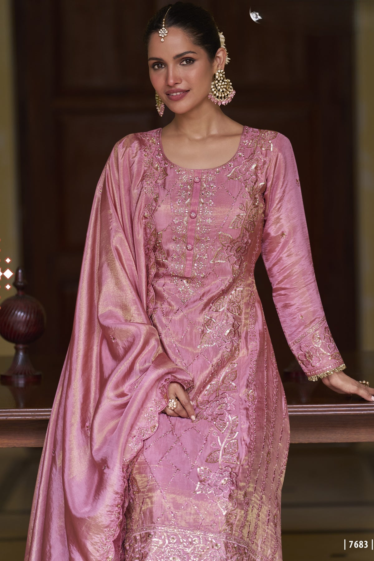 hald photo of Model wearing a light pink ladies embroidered plazo suit 