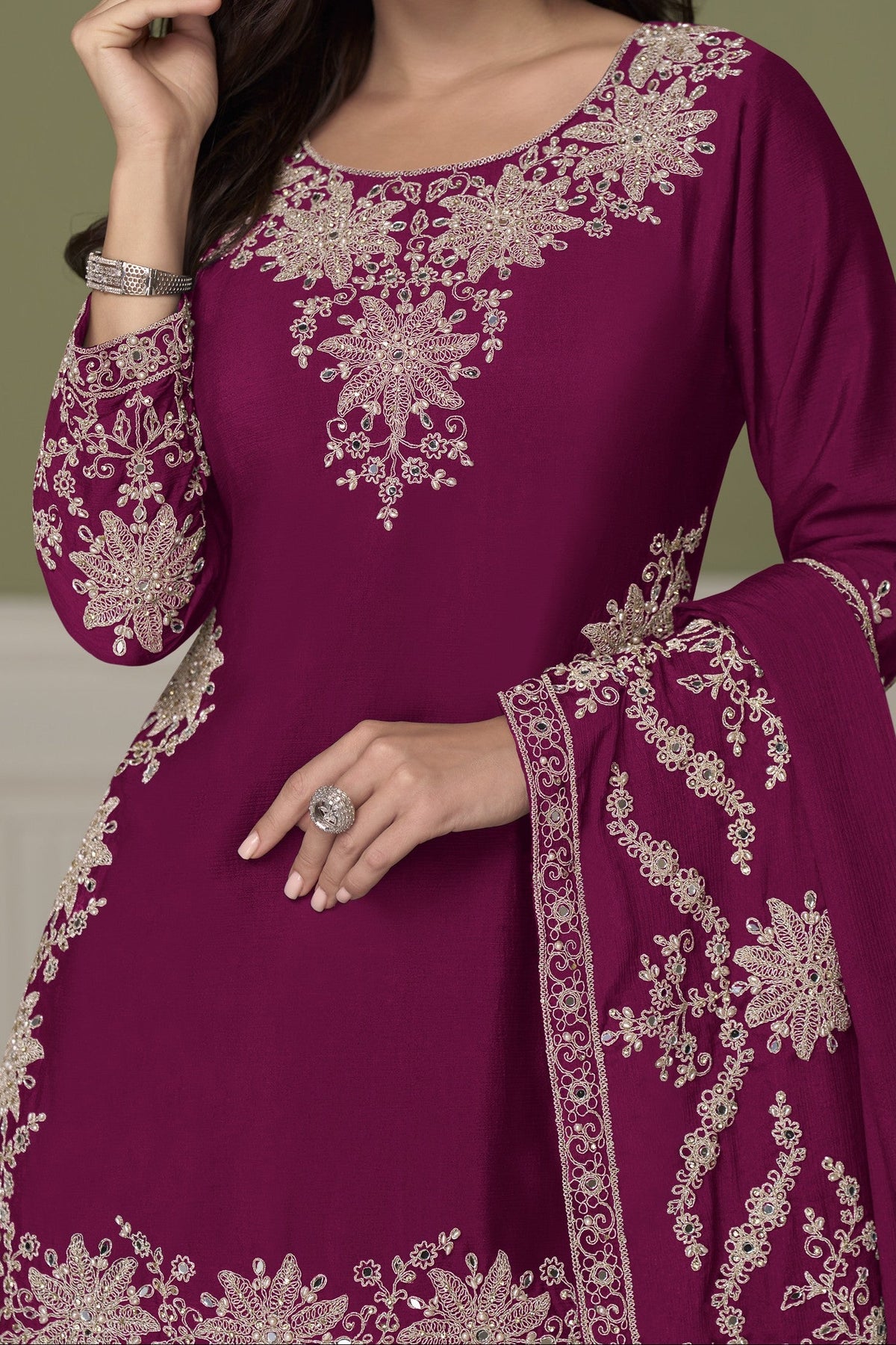 A woman modeling a Burgundy ethnic kurta with intricate embroidery, paired with a matching embroidered dupatta, set against a muted olive green background.