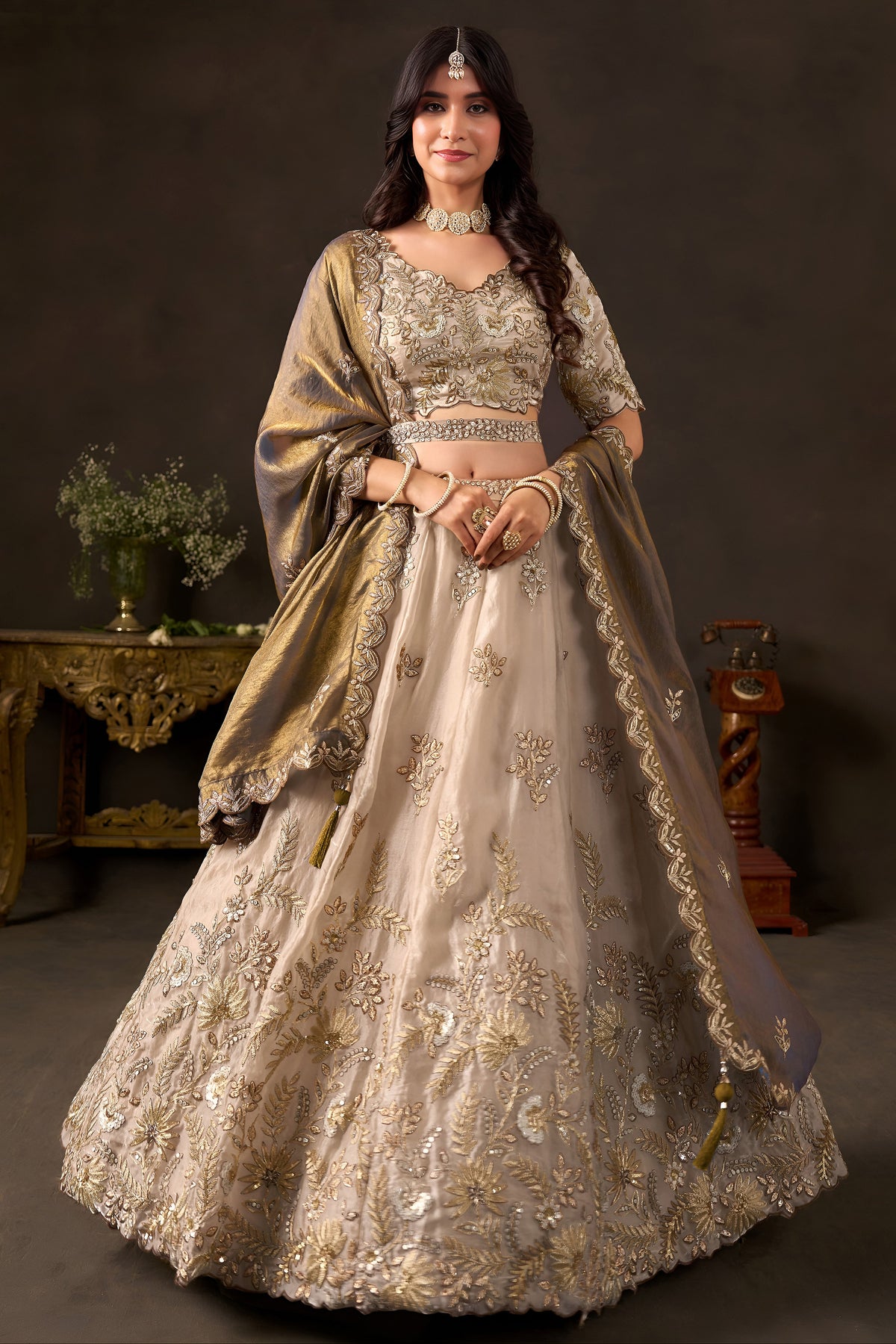 Light beige lehenga choli for wedding, full front view on model, with zari and sequin embroidery on fendy silk.