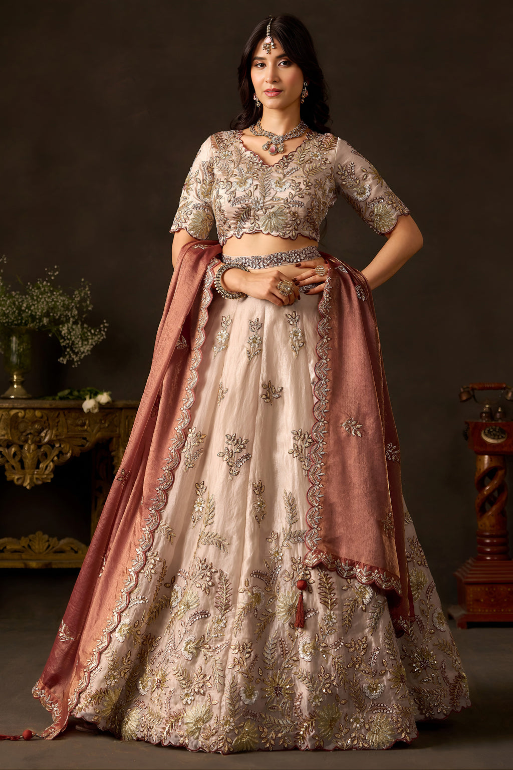 Light beige indian lehenga choli, full front view on model, with zari and sequin embroidery on fendy silk.