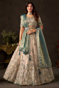 Light beige lehenga choli for sangeet, full front view on model, with zari and sequin embroidery on fendy silk.