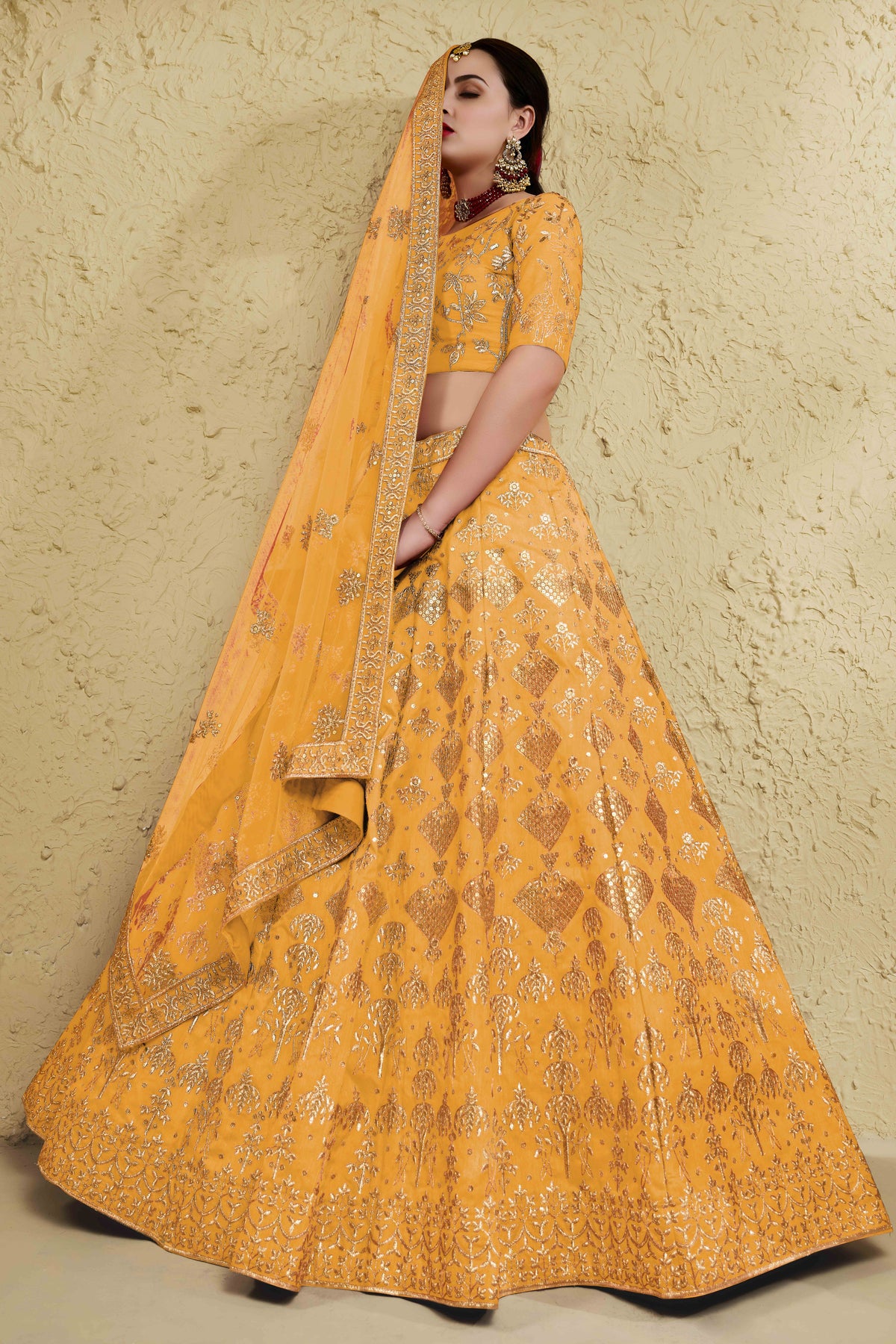 Alternate full-length view of a mustard yellow haldi outfits lehenga in art silk with zari and sequin embroidery work on the blouse and lehenga.