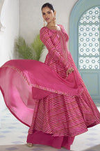 Model twirling in the fuchsia pink plazo suit, showing the flared kameez and matching dupatta.