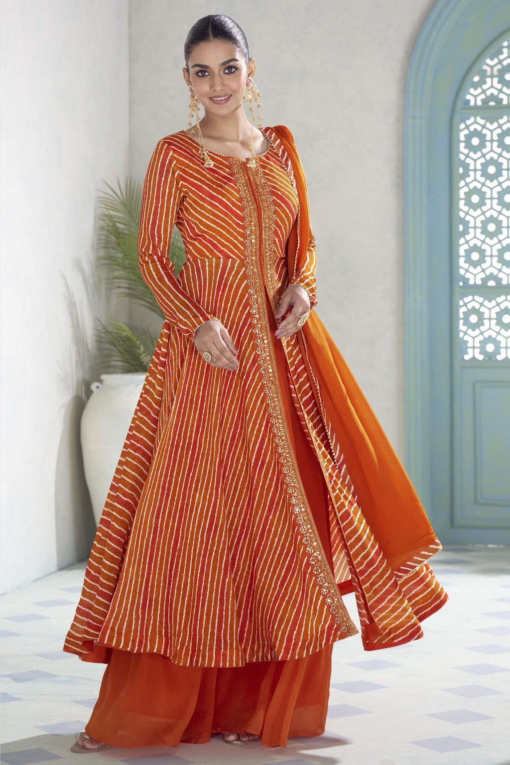 Model in the orange plazo suit showing the flared kameez and matching chinon silk dupatta.