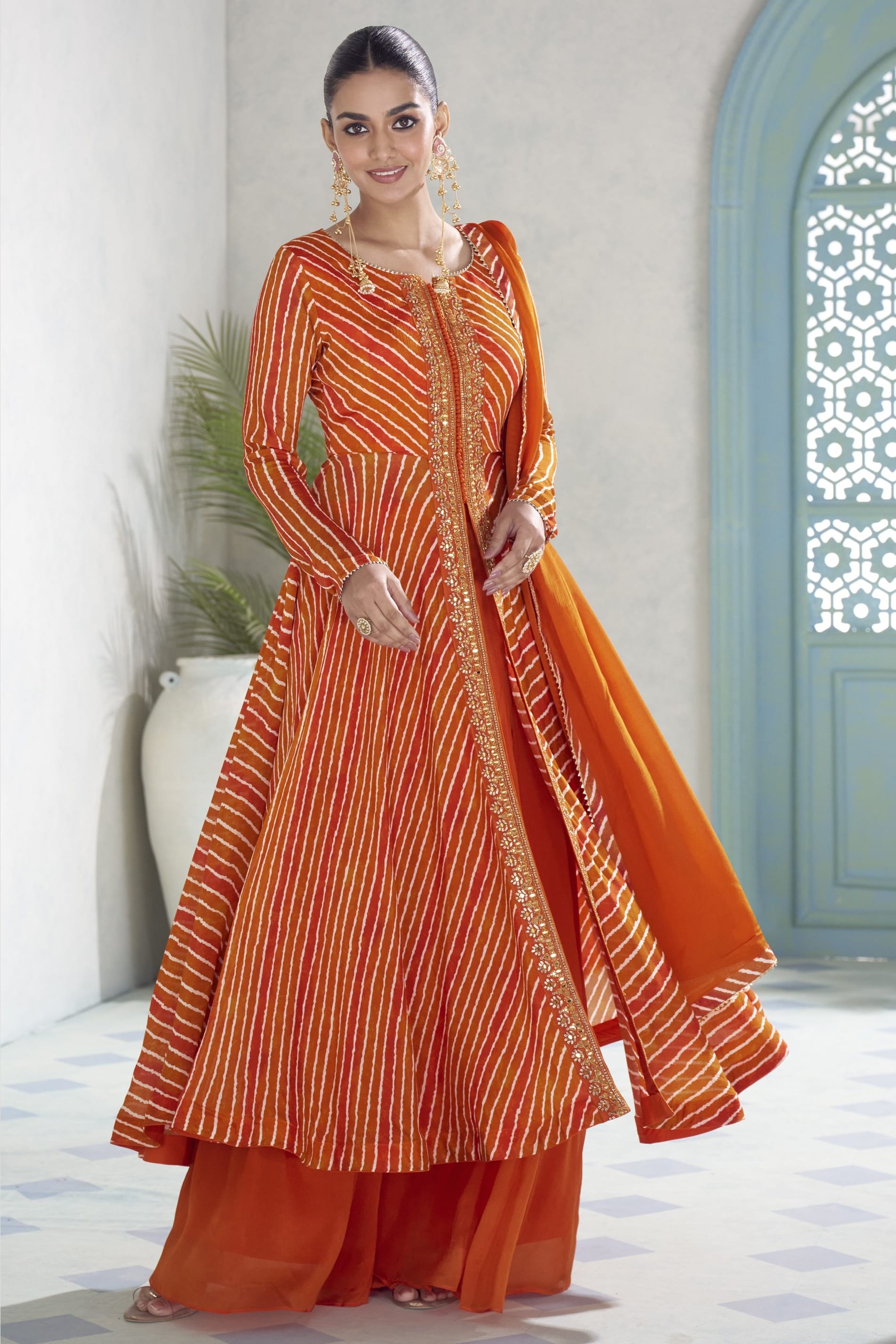 Model in the orange plazo suit showing the flared kameez and matching chinon silk dupatta.