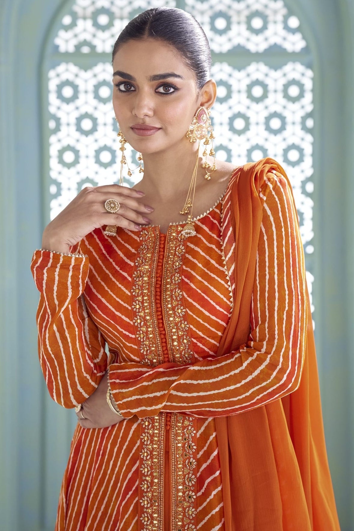 Close-up of the orange kameez front placket with sequin and thread embroidery detail.