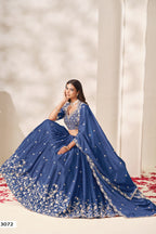 Full-length seated view of a dusty blue outfits for eid style lehenga in chinon silk with sequin and thread embroidery on the flared skirt.