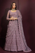 Model wearing a mauve lehenga choli for wedding with a long-sleeve embroidered blouse, flared net skirt and sheer dupatta draped over one arm.