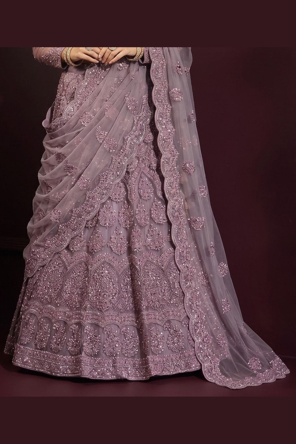 Close-up of the flared mauve lehenga choli for wedding skirt showing dense hand-worked embroidery on net from waist to hem.