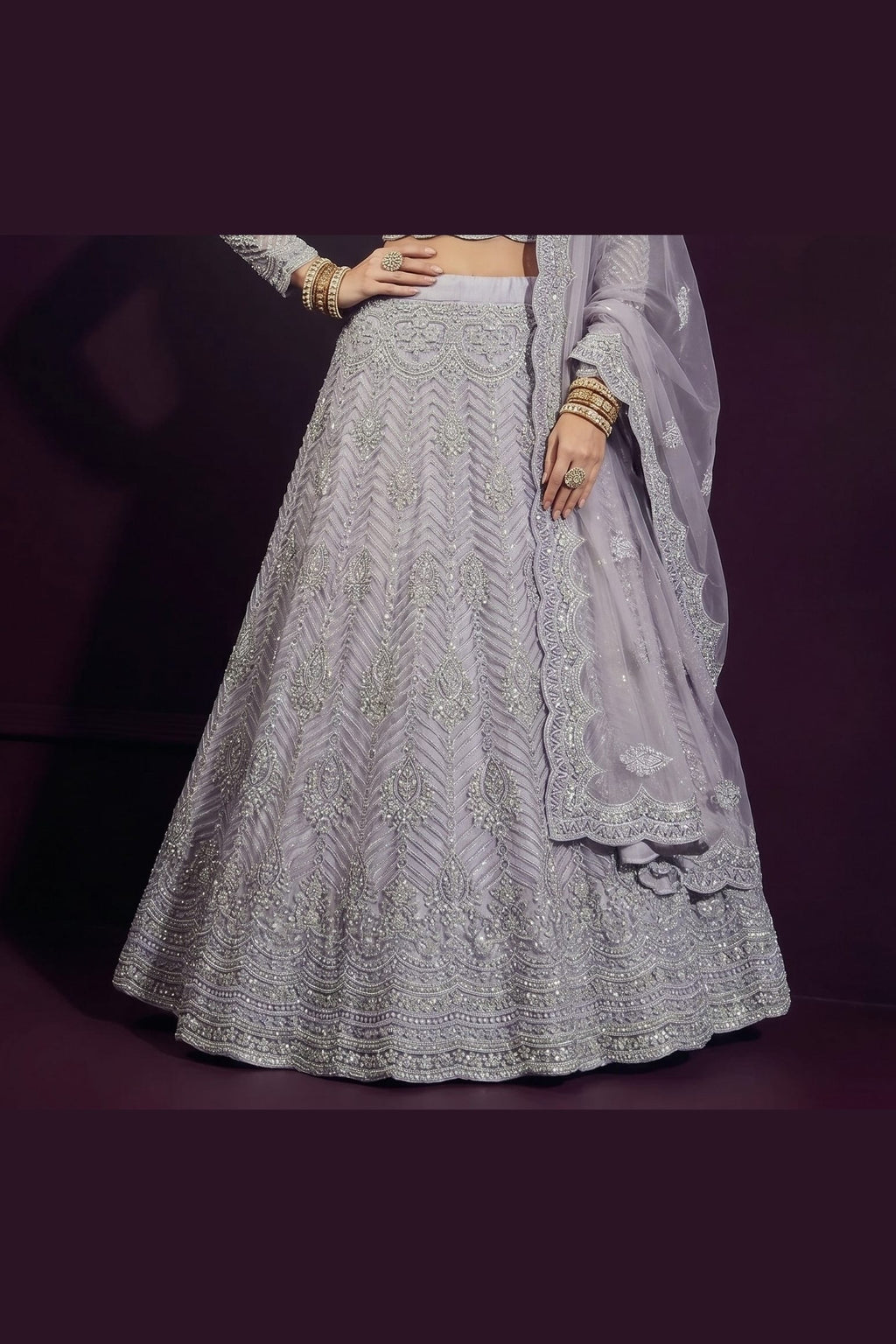 Waist-down close-up of the lavender grey engagement lehenga skirt showing chevron hand embroidery across the net fabric from waist to hem.