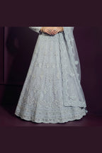 Waist-down close-up of the bluish grey reception lehenga skirt showing dense hand-worked embroidery across the net fabric from waist to hem.