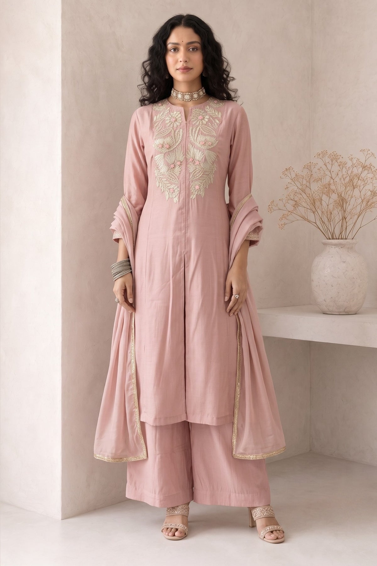 Full-length front view of a pale peach festive wear for women kurta set, an A-line kurta with ankle-length pants and tabby organza dupatta.