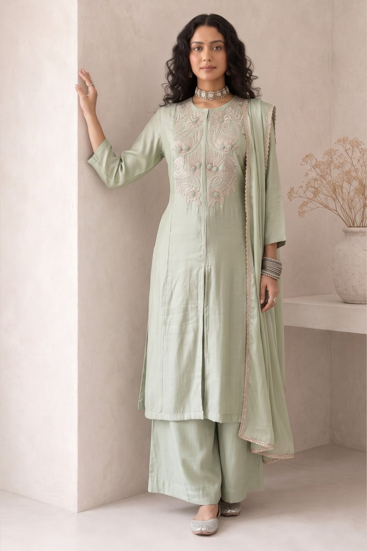 Woman wearing pastel mint green festive wear for women, an A-line kurta with ankle-length pants in roman silk, full-length front view.
