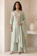 Full-length side view of pastel mint green engagement dresses for women, an A-line kurta with ankle-length pants in roman silk fabric.