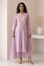 Full-length front view of a pinkish lavender women kurta set, an A-line kurta with ankle-length pants and tabby organza dupatta.