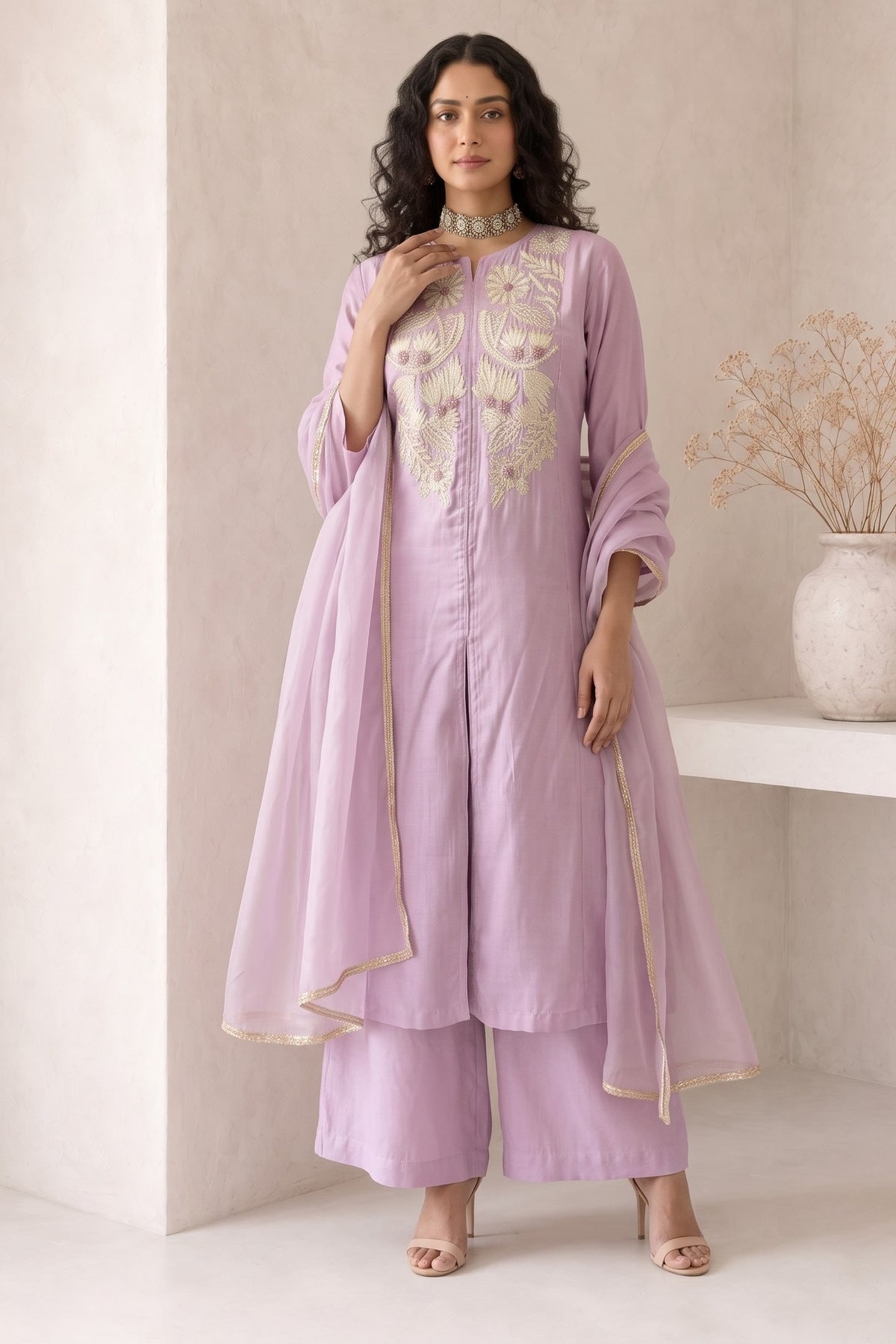 Full-length side view of a pinkish lavender festive wear for women kurta set, an A-line kurta with ankle-length pants in roman silk.