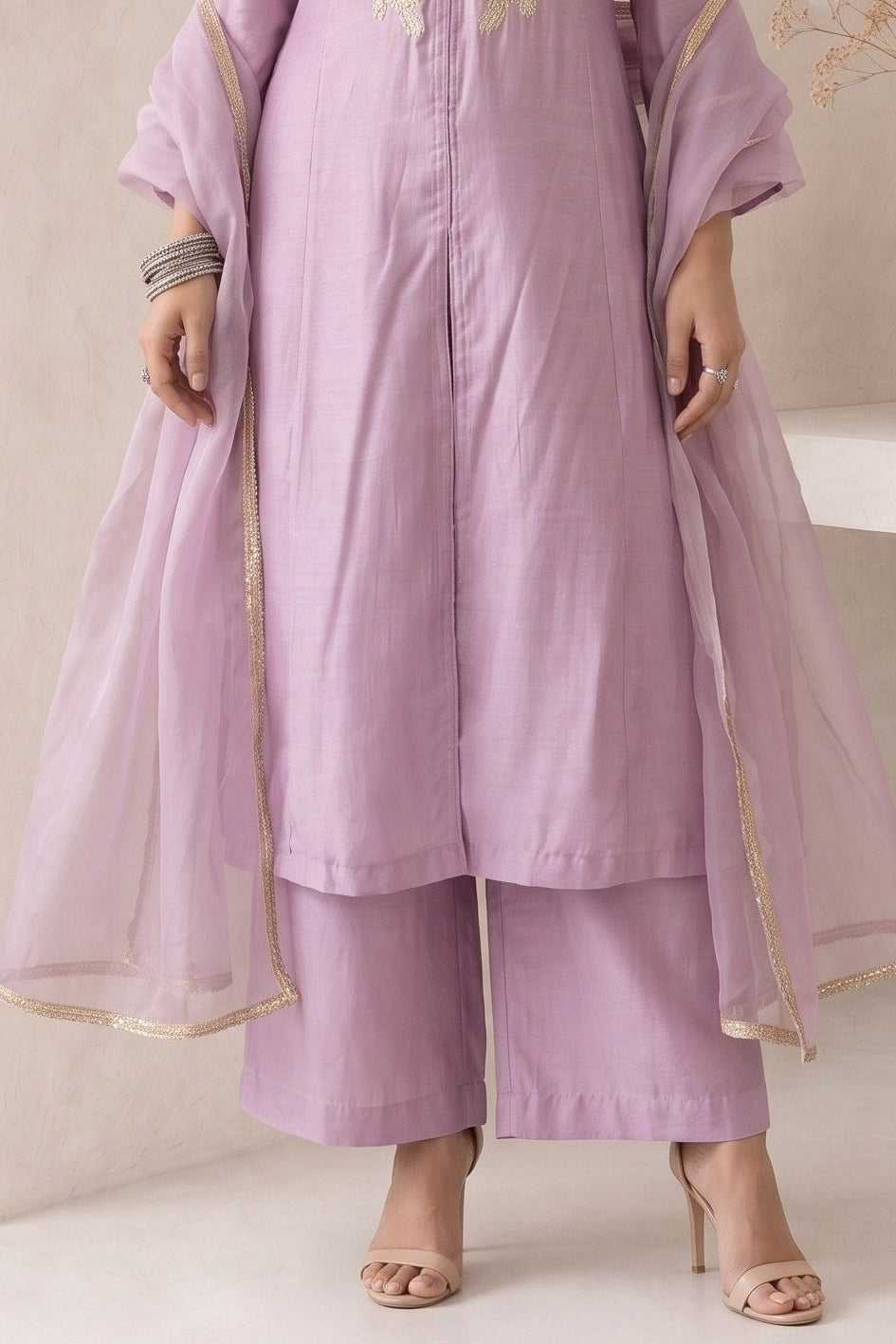 Waist-down view of a pinkish lavender engagement dresses for women kurta set, ankle-length pants with an embroidered A-line kurta in roman silk.