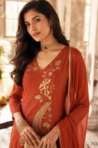 Close-up of rust indian wedding guest dresses kurta with gold zari and sequin work on the V neckline and three-quarter sleeves.