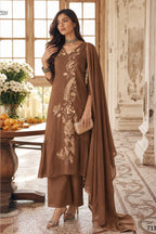 Woman wearing brown indian wedding guest dresses with an A-line pleated kurta, matching pant and net dupatta, gold zari and sequin work, full-length front view.