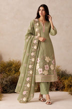 Woman wearing a sage green kurta set for women in shimmer silk with pink floral thread embroidery and chiffon dupatta, full-length front view.