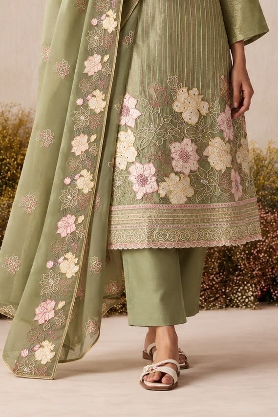 Waist-down detail view of a sage green pakistani suits style kurta pant set with floral thread embroidery on kurta hem and embroidered dupatta.