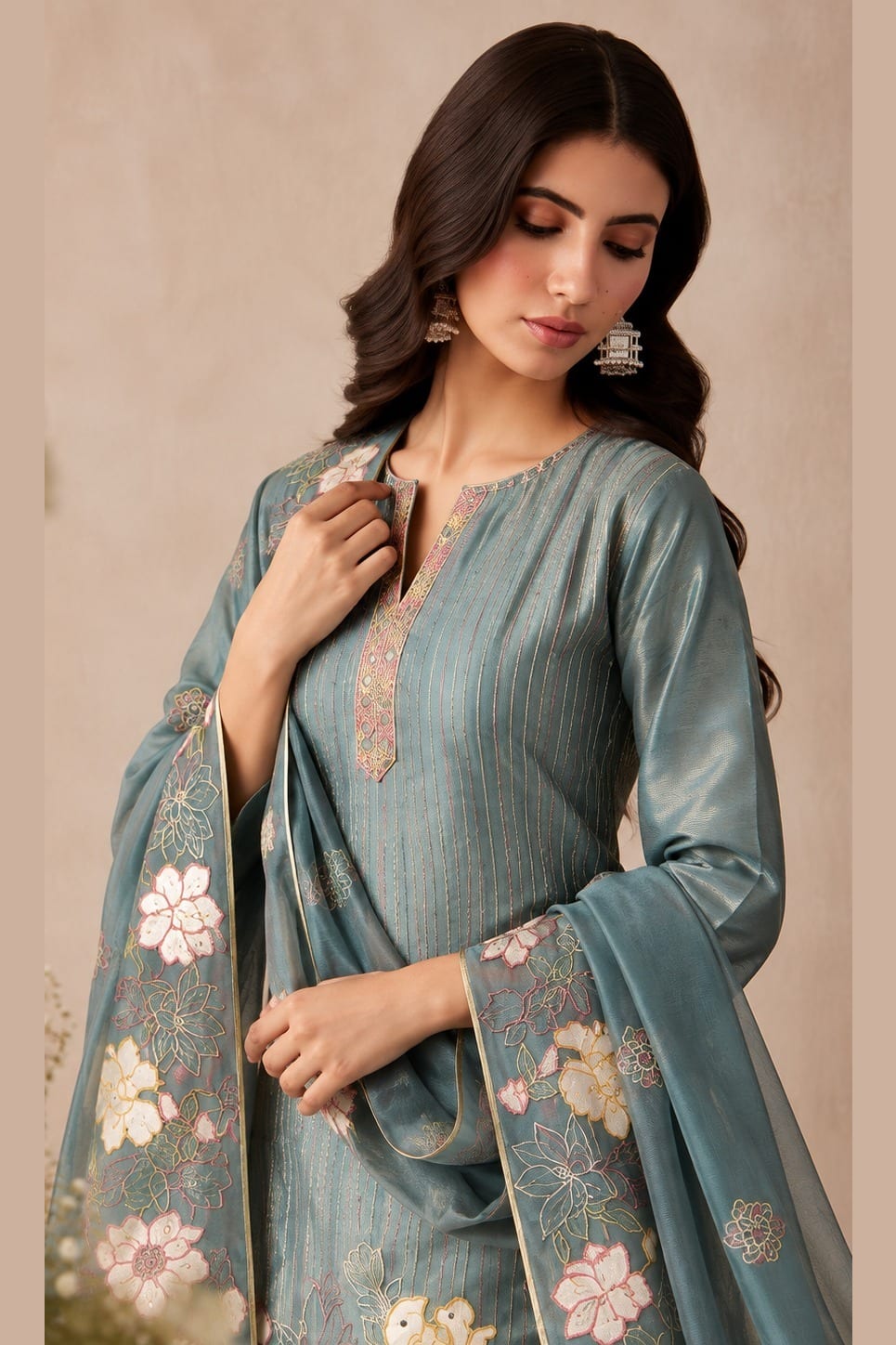 Close-up front view of a greyish blue silk salwar kameez in shimmer silk with floral thread embroidery on the kurta and dupatta border.