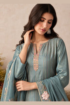 Close-up front view of a greyish blue party wear salwar kameez in shimmer silk with thread embroidered neckline and floral dupatta border.
