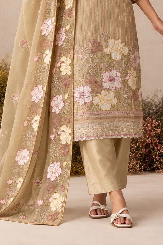 Waist-down detail view of a camel beige salwar kameez for wedding outfit with floral thread embroidery on kurta hem and santoon pant.