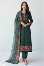 Model wearing a dark green kurta for wedding with thread, sequin and zari embroidery, straight santoon pant and sheer net dupatta with embroidered border.