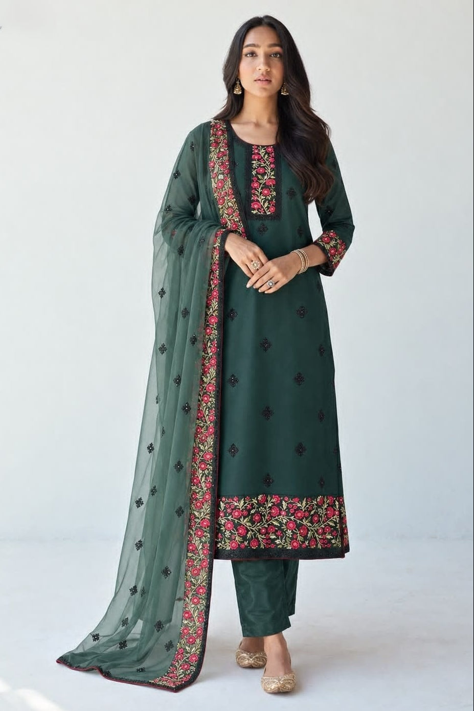 Model wearing a dark green kurta for wedding with thread, sequin and zari embroidery, straight santoon pant and sheer net dupatta with embroidered border.