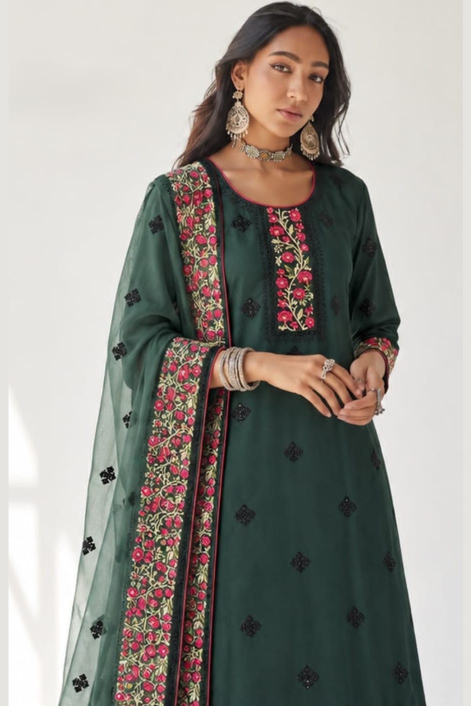 
Close-up of the dark green kurta for wedding neckline and bodice showing dense thread, sequin and zari embroidery with the sheer dupatta on the shoulder.