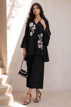 Full-length front view of a black festive wear for women co ord set, embroidered kurta with white floral embroidery and wide-leg pant.
