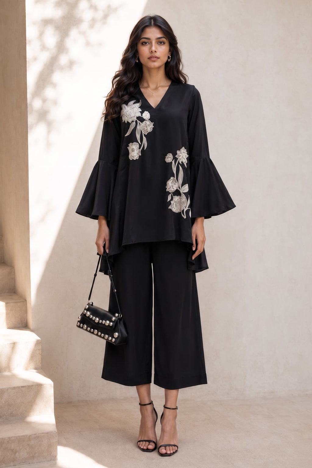 Full-length side view of a black diwali outfits for women co ord set, embroidered kurta with flared sleeves and wide-leg pant in natural crape.