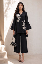 Full-length side view of a black diwali outfits for women co ord set, embroidered kurta with flared sleeves and wide-leg pant in natural crape.
