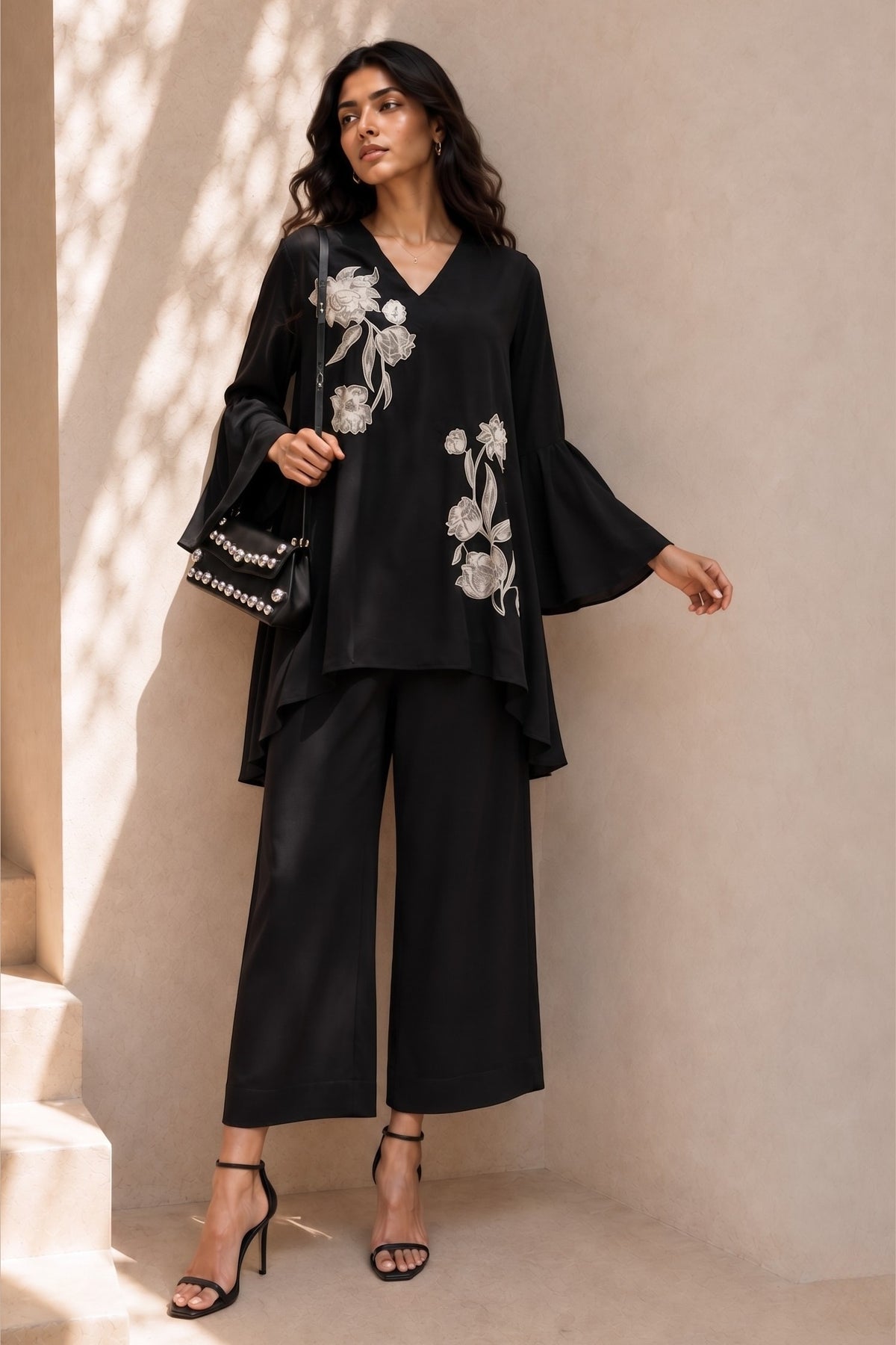 Full-length front view of a black indian co ord set, embroidered kurta with white floral embroidery and wide-leg pant in natural crape.